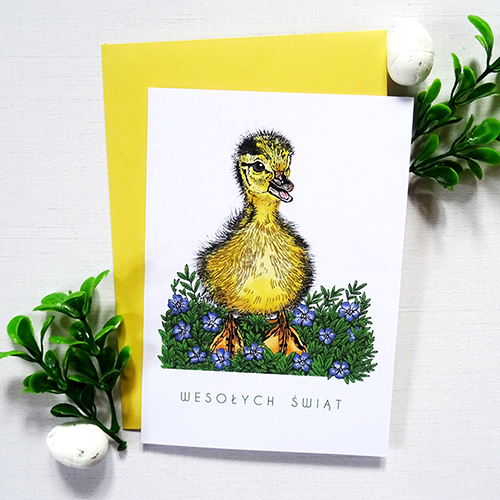 Ilustrowana Kartka Wielkanocna z Kaczuszką i wiosennymi kwiatami oraz delikatnymi złotymi detalami i napisem Wesołych Świąt.