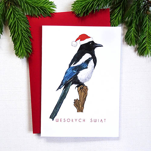 Elegancka Kartka Świąteczna z Sroką w Mikołajkowej Czapce, Ręcznie Ilustrowana wraz ze Złotymi Detalami i napisem Wesołych Świąt.