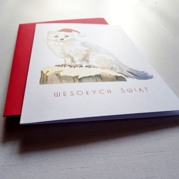 Kartka Świąteczna z uroczym Zwierzakiem, Biały Gronostaj w mikołajkowej czapeczce, wraz z napisem Wesołych Świąt i mieniącymi się złotymi detalami.